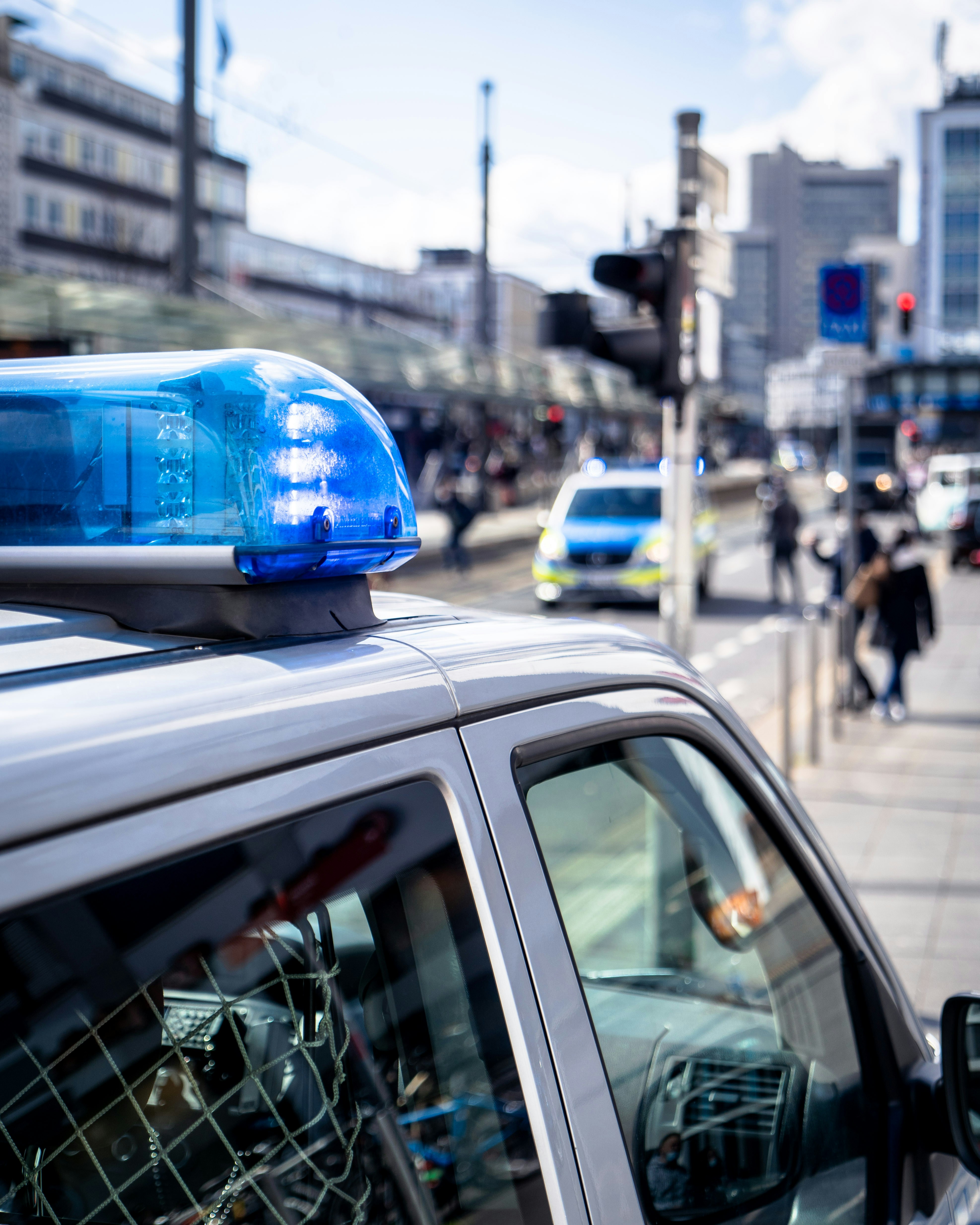 Symbolbild einer Polizeikontrolle – Einsatzfahrzeug mit Blaulicht in der Stadt als Hinweis auf Verkehrsdelikte und mögliche MPU-Anordnung nach Auffälligkeiten im Straßenverkehr.
